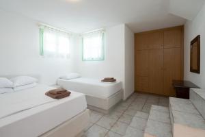 a white bathroom with a bed and a bath tub at Perseas in Naousa +17 photos