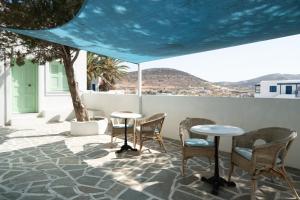 a patio with chairs and tables on a roof at Perseas in Naousa
