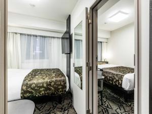 Postel nebo postele na pokoji v ubytování APA Hotel Namba Ekihigashi