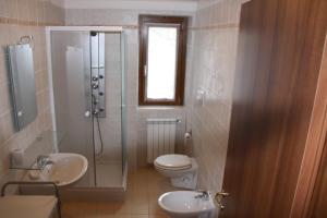 La salle de bains est pourvue d'une douche, de toilettes et d'un lavabo. dans l'établissement Alpini Apartments, à Chiesa in Valmalenco