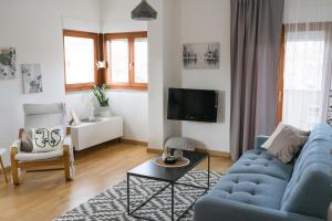 a living room with a blue couch and a tv at Apartman Krtalić in Međugorje