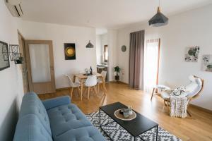 a living room with a blue couch and a table at Apartman Krtalić in Međugorje