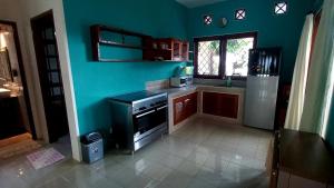 a kitchen with a stove and a blue wall at Casa Shanti in Nusa Dua
