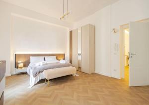 a white bedroom with a large bed and wooden floors at Residenza Camillo - Palermo Centro in Palermo