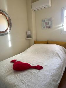 a red stuffed animal laying on a bed at New Maison tout confort, bord de mer avec Parking Privé in Gruissan +30 photos