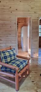 ein Sofa in einem Zimmer mit einer Holzwand in der Unterkunft Hospedaje y Cabañas Ensenada Puerto Varas in La Ensenada