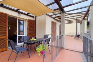 a patio with a table and chairs on a balcony at Casa Lydia in Rio nellʼElba