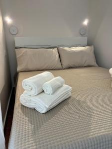 a bed with folded towels on top of it at La casa di Martina - Antica dimora vista castello in Parabita