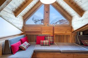 a bench in a room with a large window at Attic Apartment Dolasilla in Selva di Val Gardena