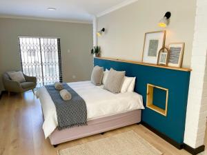 a bedroom with a large bed with a blue wall at Beachfront Corner View at Pebble Beach in Swakopmund