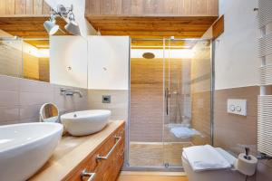 a bathroom with a sink and a glass shower at Attic Apartment Dolasilla in Selva di Val Gardena +18 photos