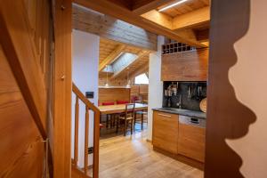 a kitchen with wooden cabinets and a dining room at Attic Apartment Dolasilla in Selva di Val Gardena