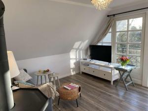 a living room with a tv and a table at Blaukehlchen in Nieblum