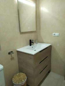 a bathroom with a sink and a mirror and a toilet at Dúplex Chiclana Centro con Terraza y Parking By Chiclana Dreams in Chiclana de la Frontera +23 photos