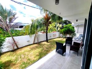 balkon ze stołem i krzesłami oraz ogród w obiekcie Labrize Apartment w mieście La Gaulette