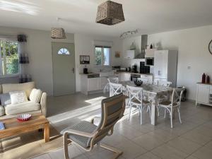 a living room and kitchen with a table and chairs at Belle maison avec piscine et terrain entièrement clôturé in Saint-Privat-de-Champclos