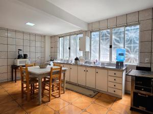 a kitchen with a table and chairs and a table and a tablektop at Casa das Palmeiras in Piratuba