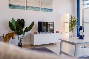 ein Wohnzimmer mit einem TV auf einem weißen Schrank in der Unterkunft Blue Nautico - penthouse with stunning views of La Herradura in La Herradura
