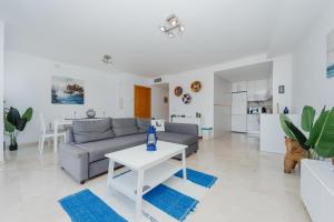ein Wohnzimmer mit Sofa und Tisch in der Unterkunft Blue Nautico - penthouse with stunning views of La Herradura in La Herradura