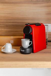 a red coffee maker and two cups on a counter at Residenza Camillo - Palermo Centro in Palermo