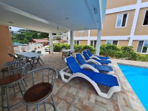 un grupo de sillas y mesas azules y una piscina en VIP Residence Dominica, en Roseau
