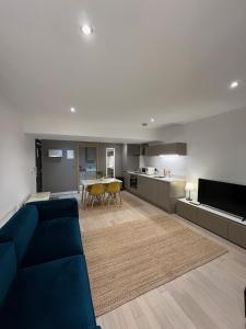 a living room with a blue couch and a kitchen at Beautiful City Centre Apartment in Liverpool