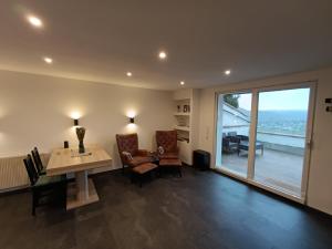Una sala de estar con una mesa y sillas y una gran ventana. en BelaVista'nBed - Peaceful Studio with private Terrace and Amazing Mosel Valley Views, en Ürzig