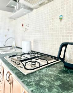 a stove top oven sitting on a counter in a kitchen at 1 комн апартаменты в центре города in Atyraū +2 photos