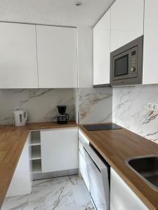 a kitchen with white cabinets and a microwave at Guacimeta in Los Pocillos