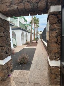 a view through a stone wall of a street at Guacimeta in Los Pocillos