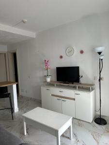 a white living room with a desk with a tv at Guacimeta in Los Pocillos