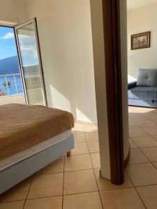 a bedroom with a bed and a view of the ocean at Boka Residence 8 in Herceg-Novi