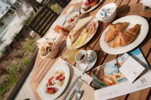 a wooden table with plates of food on it at Fantinello Hotel in Caorle