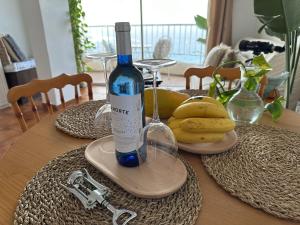 a bottle of wine sitting on a table with bananas at Atlantic Retreat in San Marcos