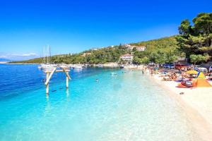 a group of people on a beach with boats in the water at Residence Paula in Jadranovo