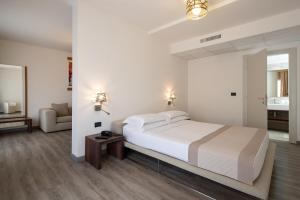 a bedroom with a bed and a living room at Fantinello Hotel in Caorle +67 photos
