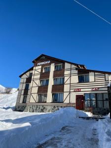 a building in the snow with a pile of snow at Soncho Gudauri in Gudauri