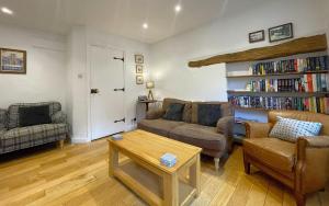 a living room with a couch and a book shelf at Barf Cottage in Portinscale