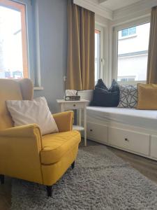 a living room with a couch and two chairs and a window at Ferienwohnung im Zentrum mit Balkon und Parkplatz in Gmunden