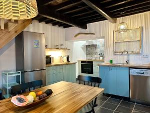 a kitchen with a wooden table with a bowl of fruit on it at Villa Tangerinetta in Ribeira das Tainhas