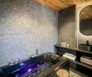 a bathroom with a purple tub and a mirror at My Way Megeve village 5 rues parking in Megève +23 photos