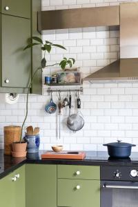 オスロにあるScandinavian Design Hideawayの緑色のキャビネットと鍋やフライパンのあるキッチン +10枚の写真