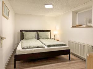 a bed with white sheets and pillows in a room at FeWo Butzbachliebe in Butzbach