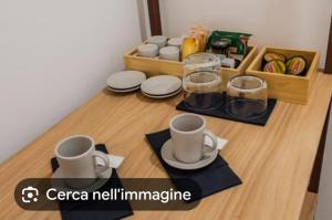 a table with two cups and plates on it at sikelia rooms in Viagrande