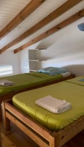 two bunk beds in a room with green sheets at Bungalows MALUEVA PREMIUM 1 chambre et 1 mezzanine à 5min de la plage de la Caravelle in Sainte-Anne