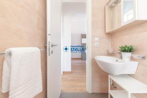 łazienka z białą umywalką i toaletą w obiekcie Condominio International w mieście Lido di Jesolo +36 zdjęć