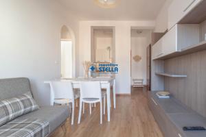 kuchnia i salon ze stołem i krzesłami w obiekcie Condominio International w mieście Lido di Jesolo