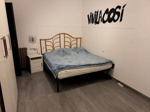 une chambre avec un lit et un panneau sur le mur dans l'établissement Casa Mare Massa Pinete, à Marina di Massa