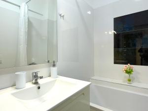 un bagno bianco con lavandino e specchio di Bella Vista Green Apartment a Braşov Altre 15 foto