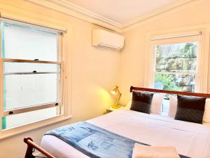un dormitorio con una cama y una ventana en Kent St Townhouse, en Sídney
